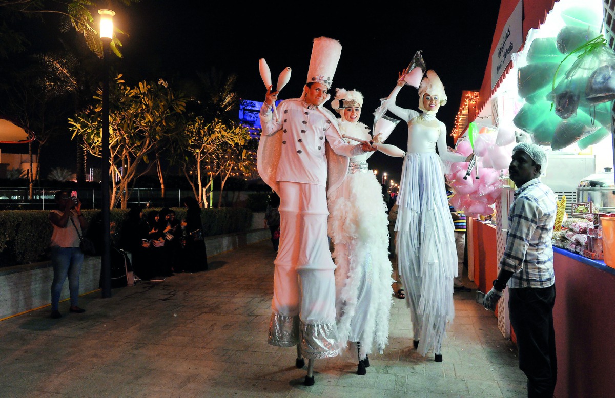 Stilt walkers entertaining visitors at the Qatar International Food Festival at Hotel Park, yesterday.  Pic: Kammutty V P / The Peninsula