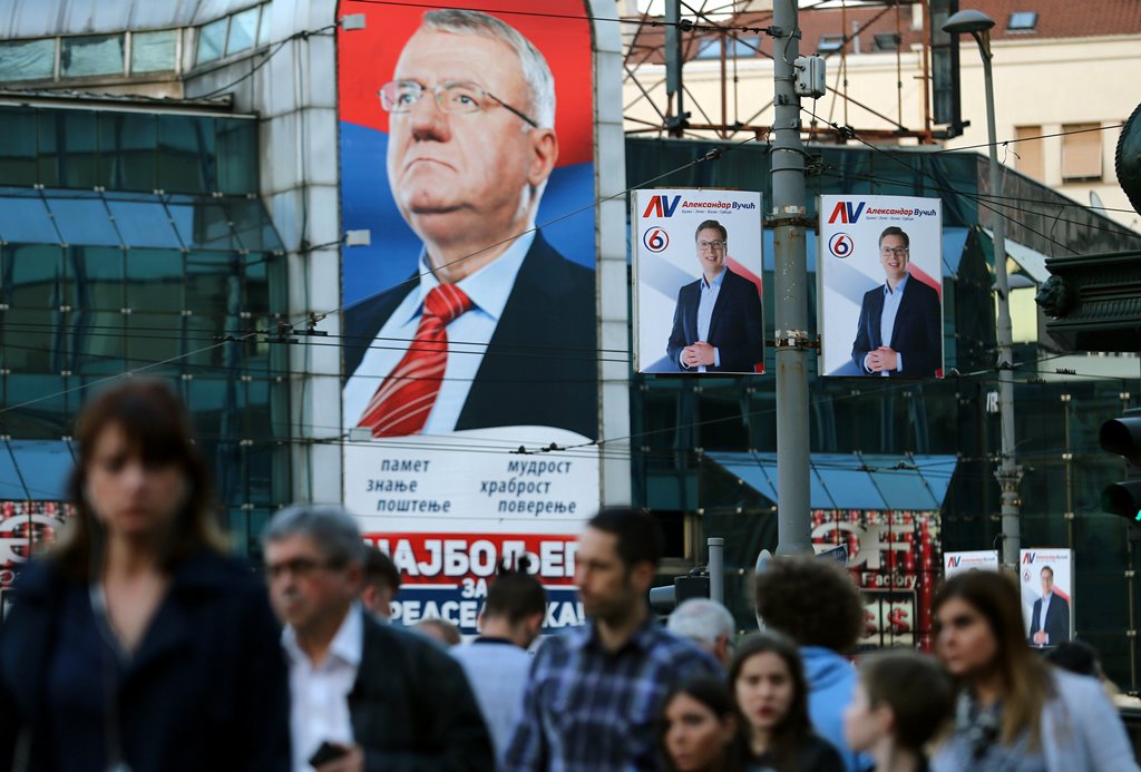 People walk past posters of Serbian Prime Minister and presidential candidate Aleksandar Vucic (R) and Vojislav Seselj in Belgrade, Serbia, March 31, 2017. Reuters/Antonio Bronic
