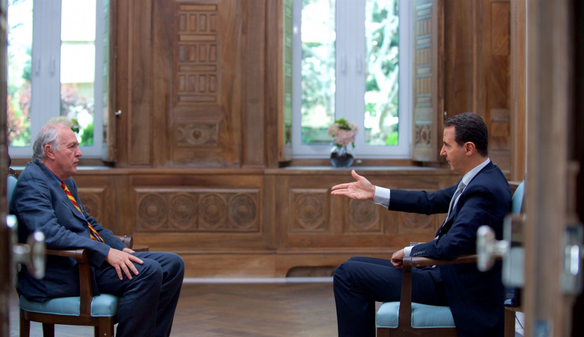 A handout picture released by the Syrian presidency's press office shows Syrian President Bashar al-Assad (R) during an interview with AFP's Beirut bureau chief Sammy Ketz in the capital Damascus, on April 12, 2017. / AFP / Syrian Presidency Press Office 