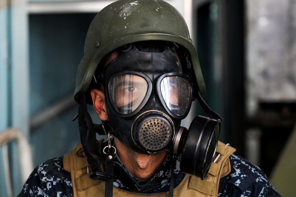 A member of the Iraqi forces wears a gas mask in the old city of Mosul on April 16, 2017, during an offensive to recapture the city from Islamic State (IS) group fighters. / AFP / AHMAD AL-RUBAYE
