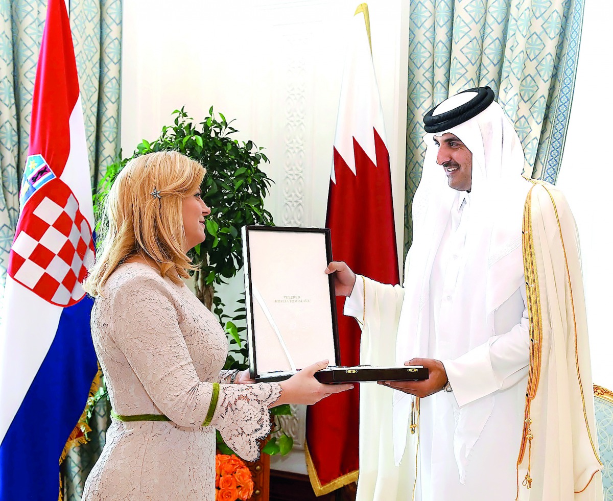 Emir H H Sheikh Tamim bin Hamad Al Thani receiving the Grand Order of King Tomislav with Sash and Great Star, the highest state order of the Republic of Croatia, from President Kolinda Grabar-Kitarovic, at Emiri Diwan yesterday.