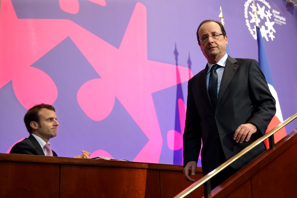 (FILES) This file photo taken on June 20, 2013 shows French President's deputy General Secretary Emmanuel Macron (L) looking on as President Francois Hollande leaves the stage after delivering his speech at the Social Conference, a 2-day conference to dis