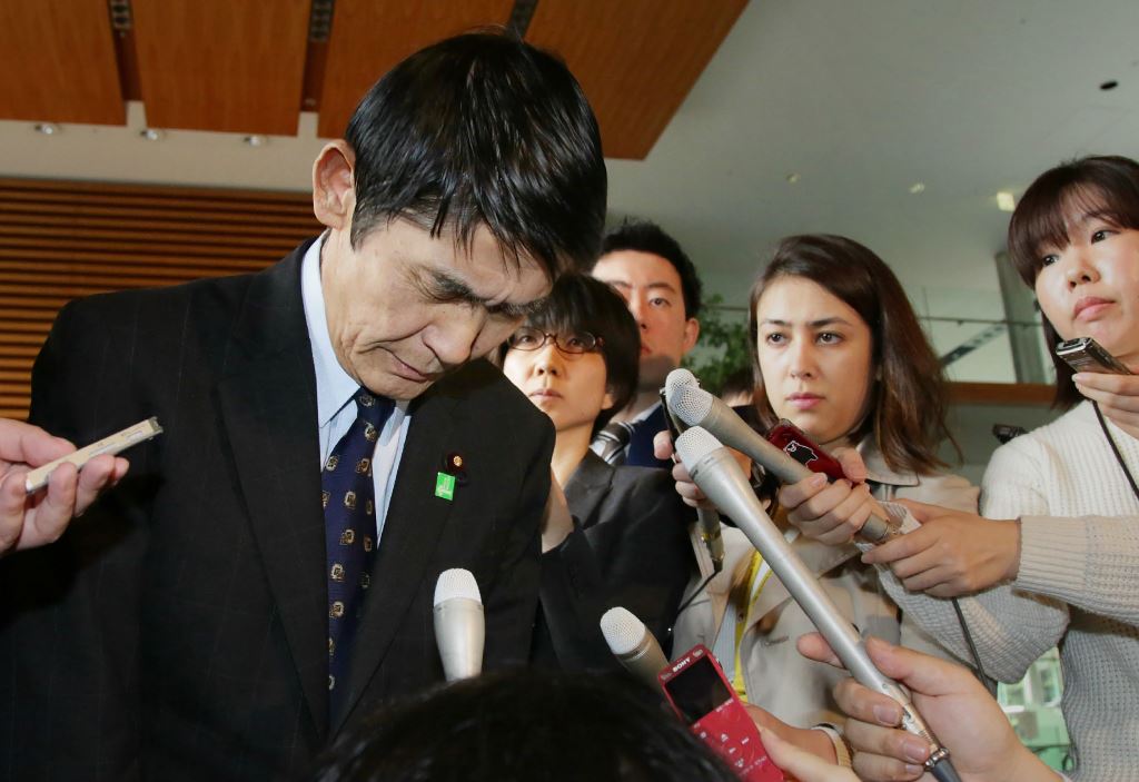 Surrounded by reporters, Japan's Disaster Reconstruction Minister Masahiro Imamura bows after submitting his resignation to Prime Minister Shinzo Abe at Abe's official residence in Tokyo on April 26, 2017. Japan OUT / AFP / JIJI PRESS / STR