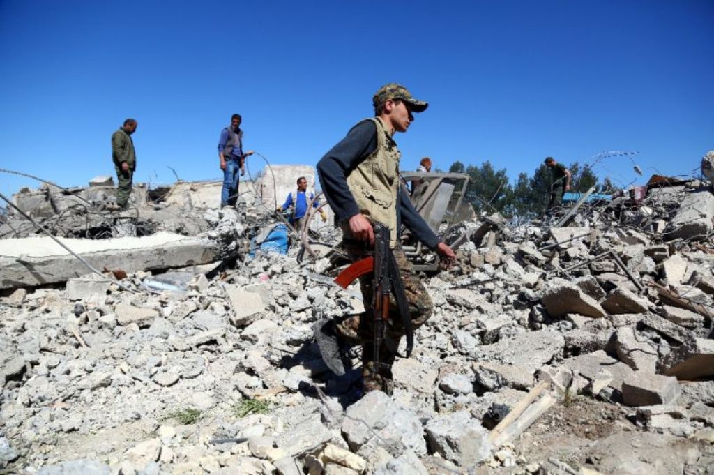 Fighters from the Kurdish People's Protection Units (YPG) visit the site of Turkish airstrikes near northeastern Syrian Kurdish town of Al-Malikiyah on April 25, 2017 (AFP Photo/DELIL SOULEIMAN).