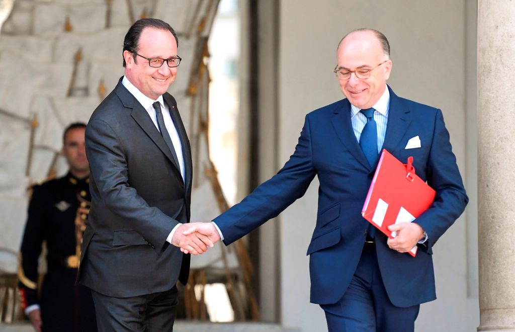 Fench President Francois Hollande (L) shakes hands with French Prime Minister Bernard Cazeneuve as he leaves the weekly cabinet meeting on April 26, 2017 at the Elysee presidential Palace in Paris. / AFP / STEPHANE DE SAKUTIN
