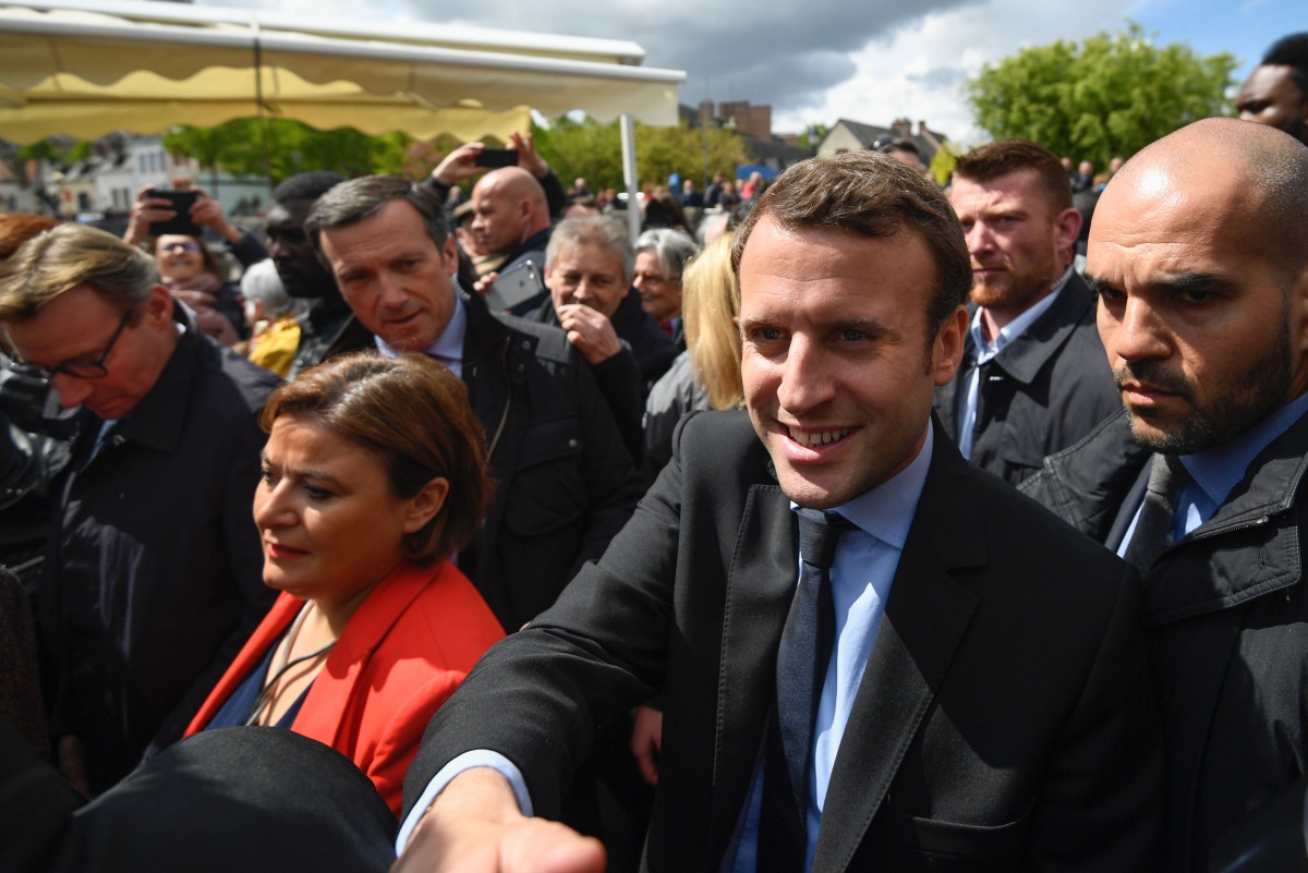 French presidential election candidate for the En Marche ! movement Emmanuel Macron (R) shakes hands with people as he arrives to visit the Whirlpool factory in Amiens, northern France, on April 26, 2017.  AFP / Eric Feferberg