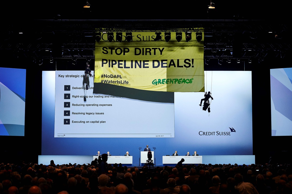 Environmental group Greenpeace activists hanging on ropes mount a banner reading 