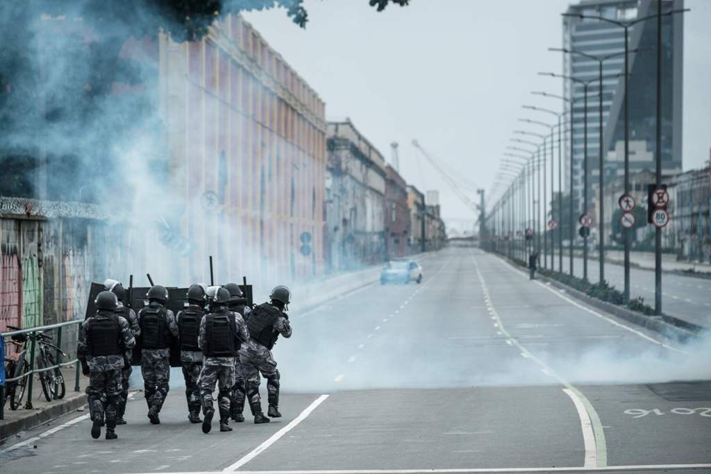 PM militarized police personnel in riot gear fire tear gas at protestors blocking the road before the long-distance bus terminal during the nationwide strike called by unions opposing austerity reforms in Rio de Janeiro, Brazil, on April 28, 2017. / AFP.