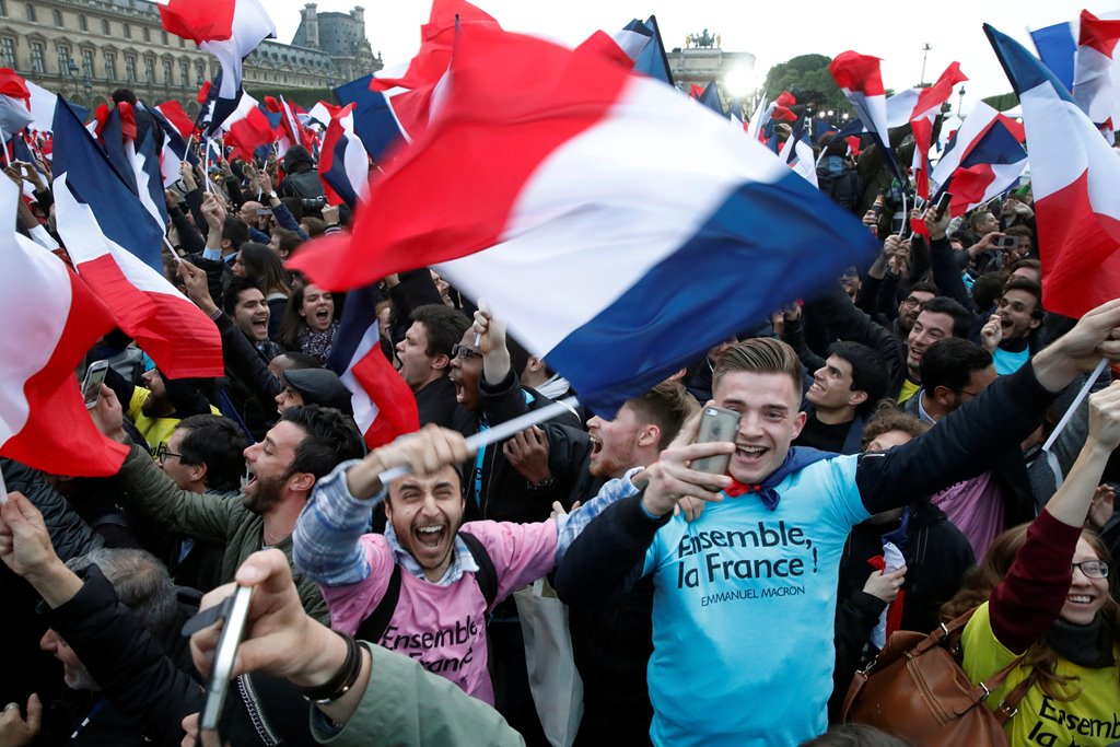 Supporters of French President Elect Emmanuel Macron celebrate near the Louvre museum after early results were announced in the second round vote in the 2017 presidential elections in Paris, France, May 7, 2017. REUTERS/Christian Hartmann