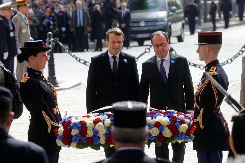 Outgoing French President Francois Hollande (R) and President-elect Emmanuel Macron attend a ceremony to mark the end of World War II at the Tomb of the Unknown Soldier at the Arc de Triomphe in Paris, France, May 8, 2017. REUTERS/Philippe Wojazer.