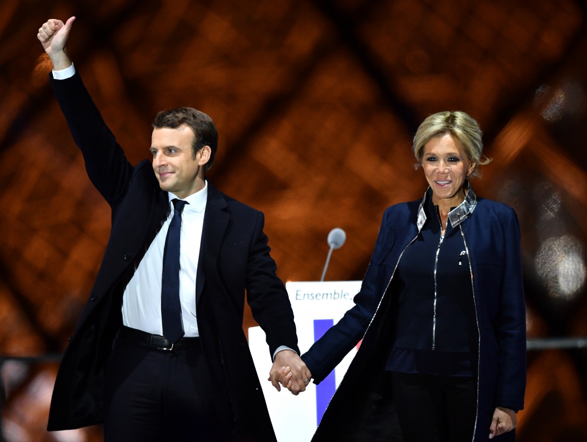 French presidential election candidate for the 'En Marche!' (Onwards!) political movement, Emmanuel Macron (L) greets with his wife Brigitte Trogneux (R) after winning the 2017 French election at the Esplanade du Louvre in Paris, France on May 07, 2017. (