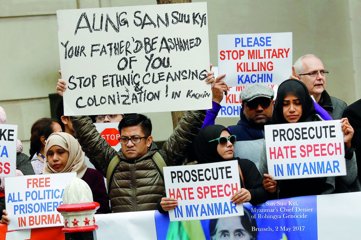 Protesters hold placards as Myanmar's leader Aung San Suu Kyi visits the Guildhall in London, yesterday. 