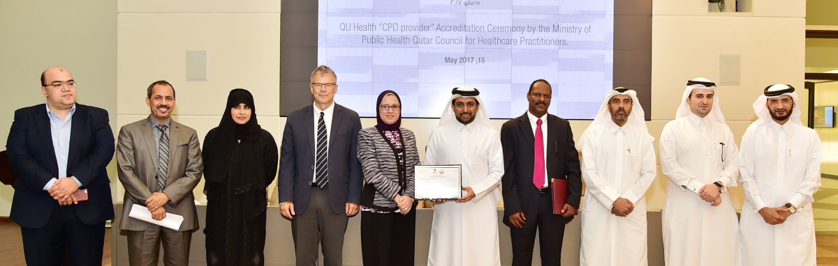 QU President Dr Hassan Al Derham, faculty members and officials with the accreditation certificate. 