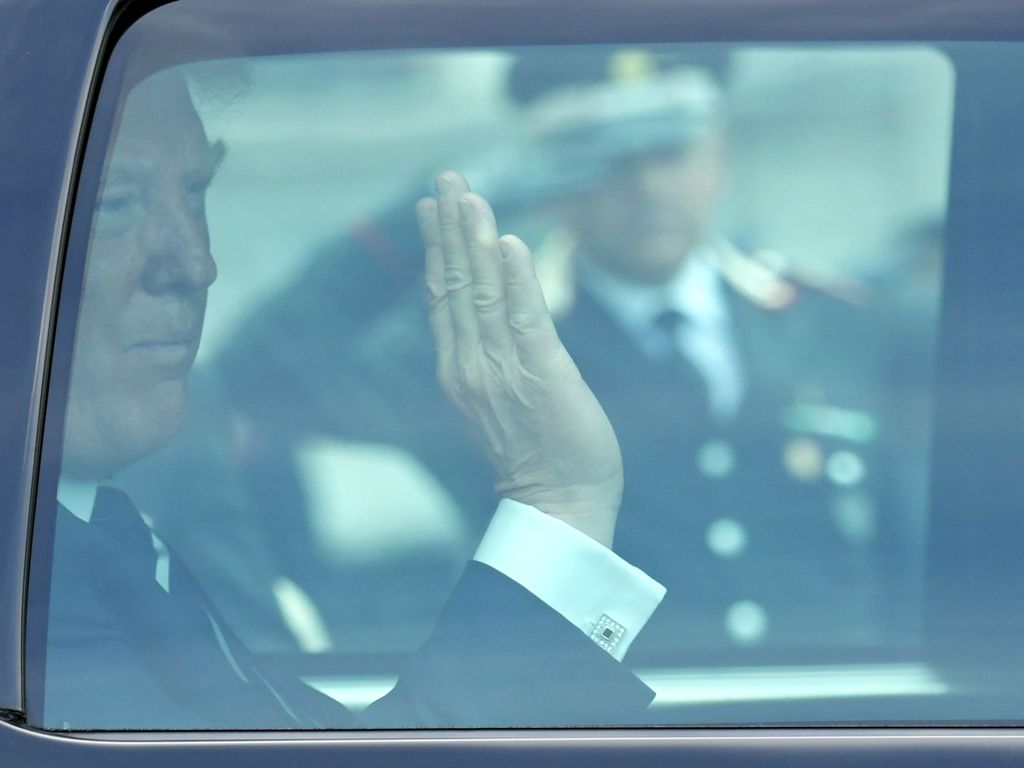 US President Donald Trump waves through the window of his vehicle as he leaves the Quirinale Presidential Palace after a meeting with Italy's President Sergio Mattarella, on May 24, 2017 in Rome. / AFP / Andreas SOLARO
