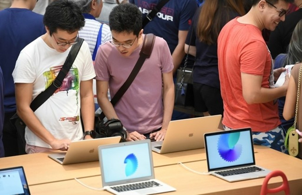 People look at products on display inside the Apple store in the Orchard shopping district on its opening day in Singapore on May 27, 2017. / AFP / Roslan RAHMAN.