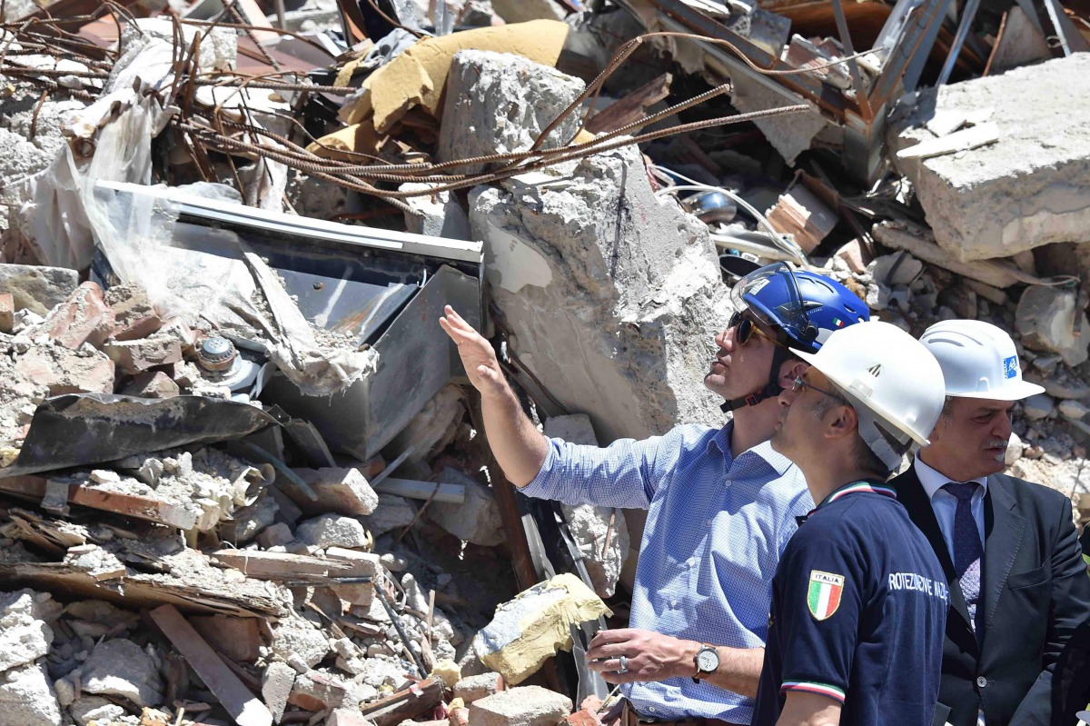 Canadian Prime Minister Justin Trudeau (L) is escorted by officials during a visit in earthquake-devastated village Amatrice, on May 28, 2017. Amatrice is part of the area affected by the earthquake that occurred in August 2016 in central Italy. (AFP / PO