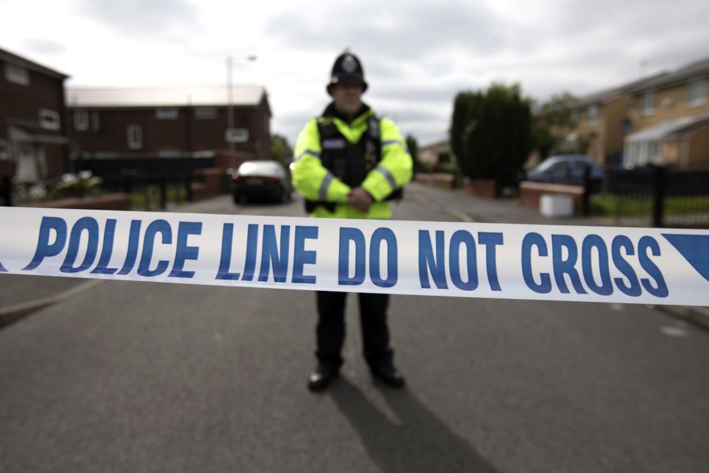 A police officer guards the entrance to a street in the Moss Side area of Manchester on May 28, 2017 during an operation. AFP / JOHN SUPER