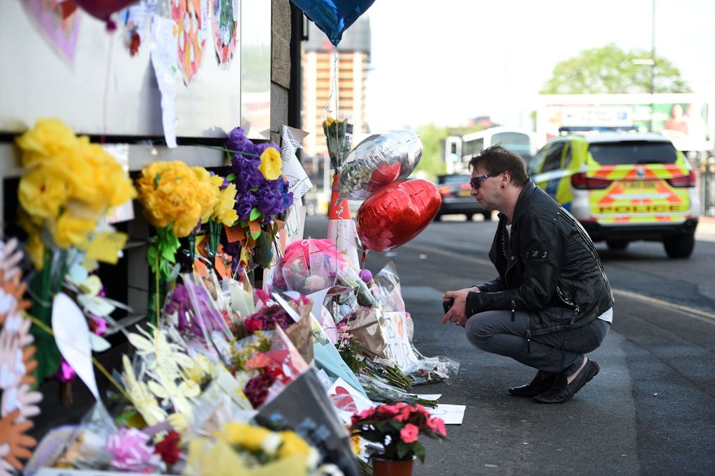 Well wishers look at messages of support and floral tributes to the victims of the Manchester attack,outside the Manchester Arena Complex in Manchester on May 27, 2017.   AFP / Oli SCARFF
