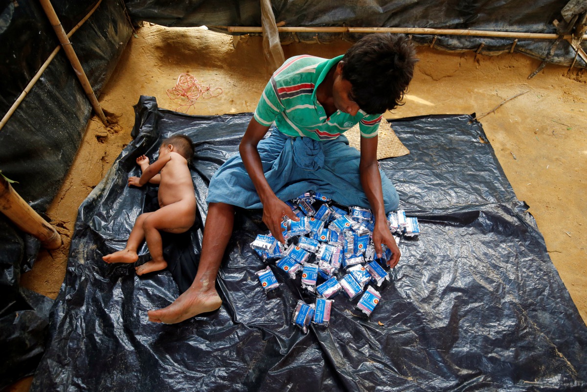 A Rohingya refugee man counts the number of biscuit packets he received as relief at the Balukhali Makeshift Refugee Camp in Cox’s Bazar, Bangladesh May 31, 2017. Reuters/Mohammad Ponir Hossain