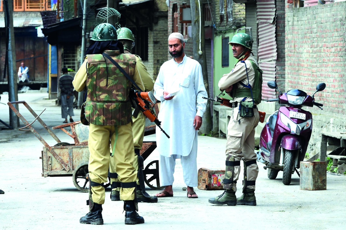 Paramilitary troopers stop a resident during a curfew and strike in Srinagar, yesterday.
