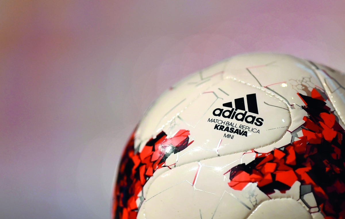 The sign of the German sports goods company Adidas is seen at the mini version of the official match ball 