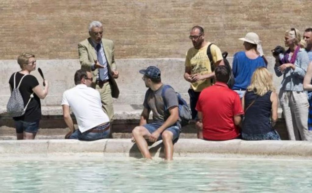 A tourist baths his feet in the Trevi Fountain in Rome on Monday