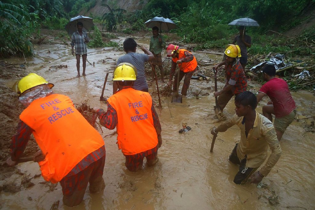 Bangladeshi fire fighters and residents search for bodies after a landslide in Bandarban on July 13, 2017. Heavy monsoon rains have killed at least 46 people in southeast Bangladesh, most of them buried under landslides, authorities said on July 13.   AFP