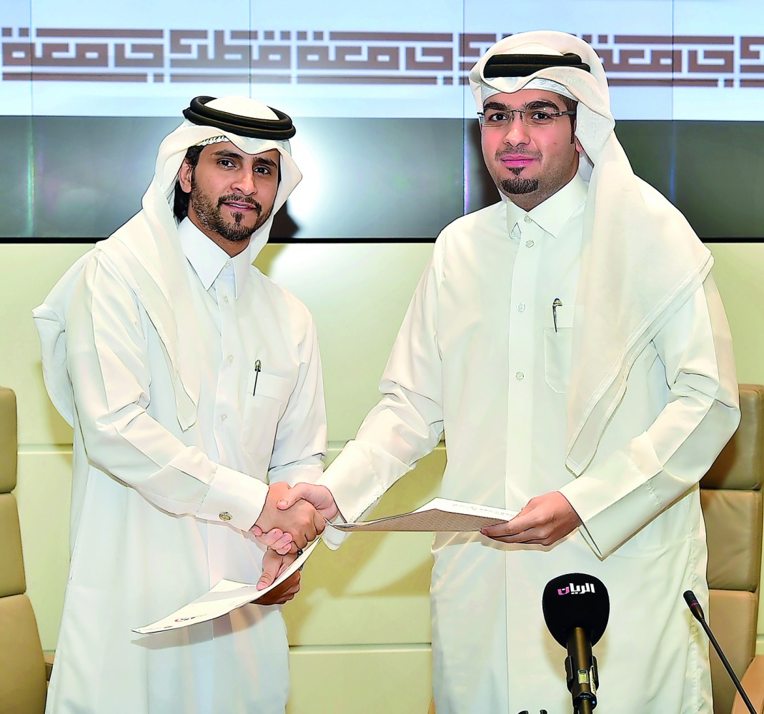 Abdulla Al Yafei (left), QU Student Services and Activities Director and Mohammed Yousef Al Otaibi, QYH Deputy Executive Director during the signing ceremony. 
