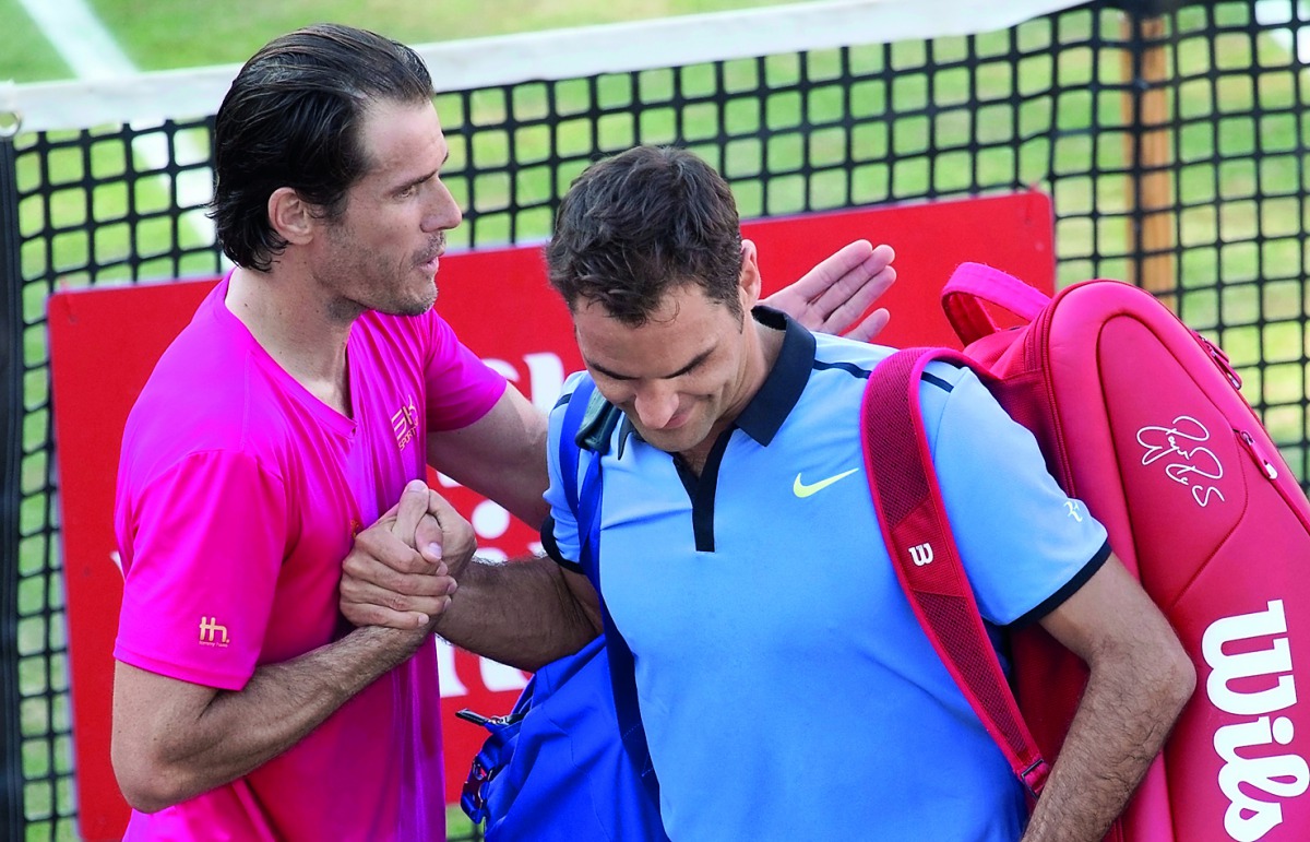 Germany's Tommy Haas (left) comforts Roger Federer after the match.