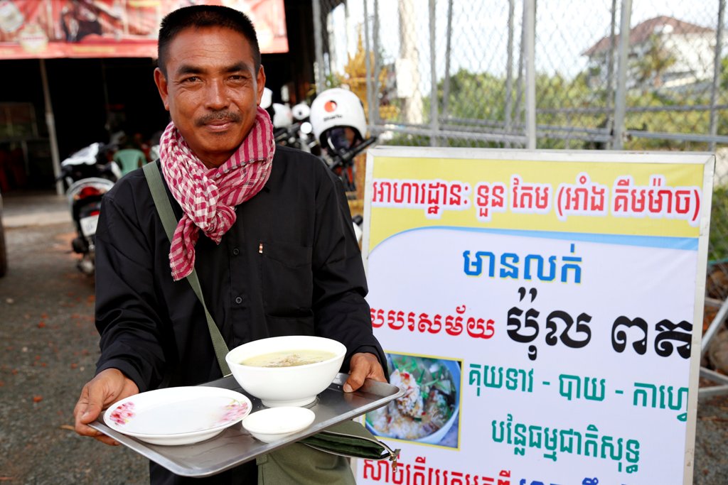 Tuon Tem, 49, holds a bowl with porridge outside of his restaurant in Siem Reap province, Cambodia, June 19, 2017. REUTERS/Stringer.