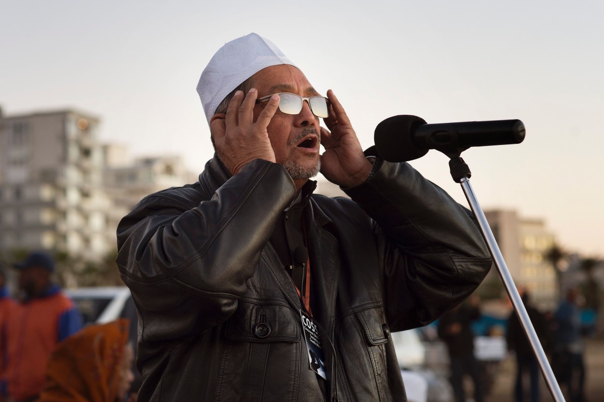 A Muezzin calls to attend the evening prayer at Three Anchor Bay in Cape Town on June 24, 2017. AFP / Rodger Bosch