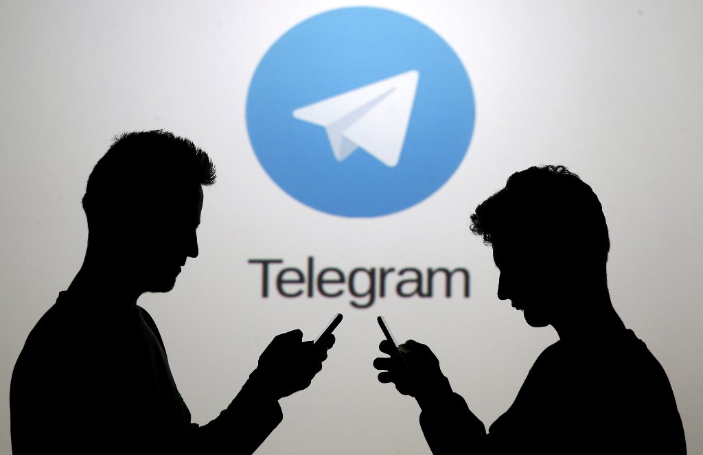 FILE PHOTO: Men pose with smartphones in front of a screen showing the Telegram logo in this picture illustration November 18, 2015. REUTERS/Dado Ruvic/File Photo
