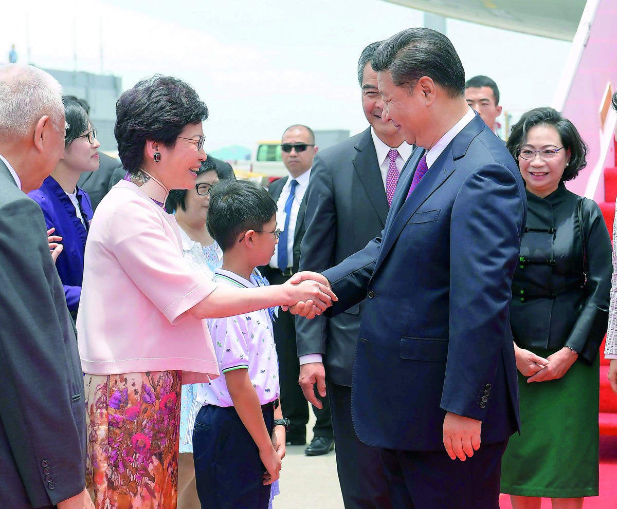 Chinese President Xi Jinping is welcomed by Chief Executive-elect Carrie Lam upon Xi's arrival in Hong Kong, yesterday.
