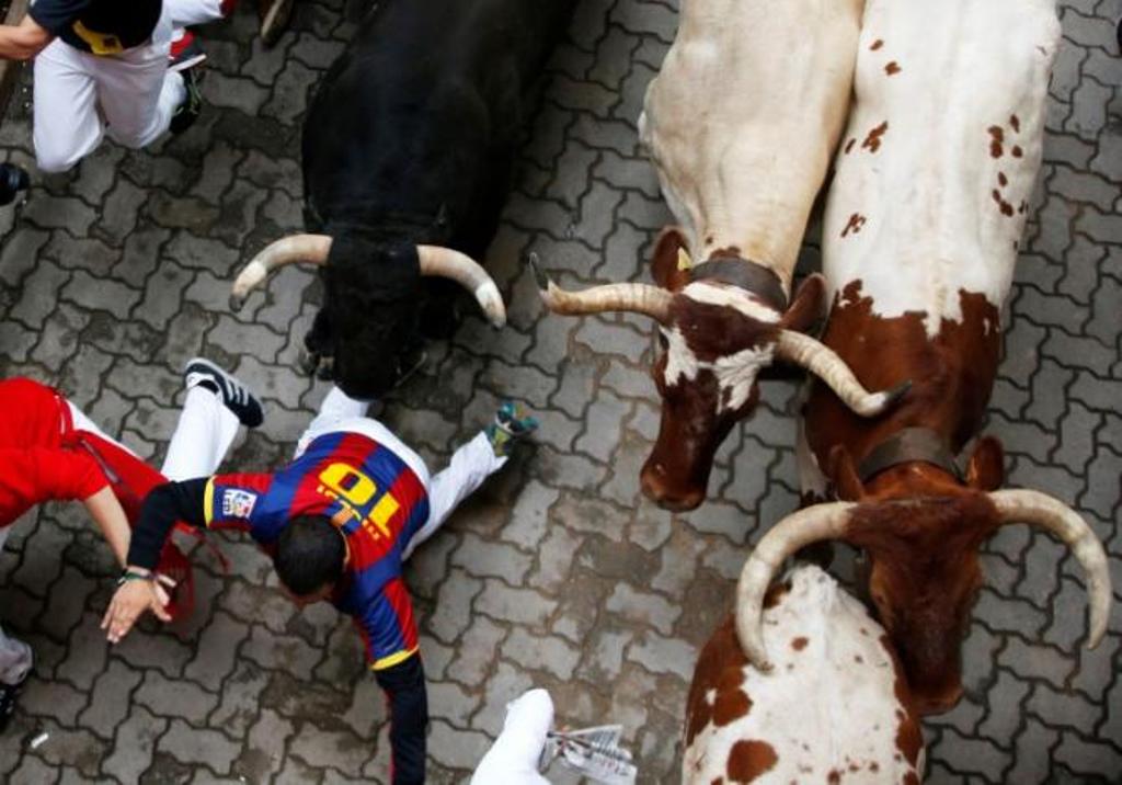 A runner falls in front of bulls during the fifth Running of the Bulls at the San Fermin festival in Pamplona, Spain July 11, 2017. REUTERS/Susana Vera.