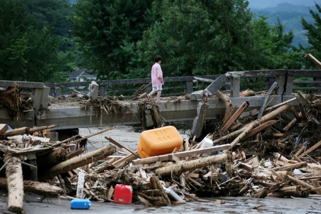 A resident walks across a damaged bridge in a flooded area in Asakura city, Fukuoka prefecture on July 11, 2017. / (AFP PHOTO / JIJI PRESS / STR / Japan OUT / Manila Bulletin).
