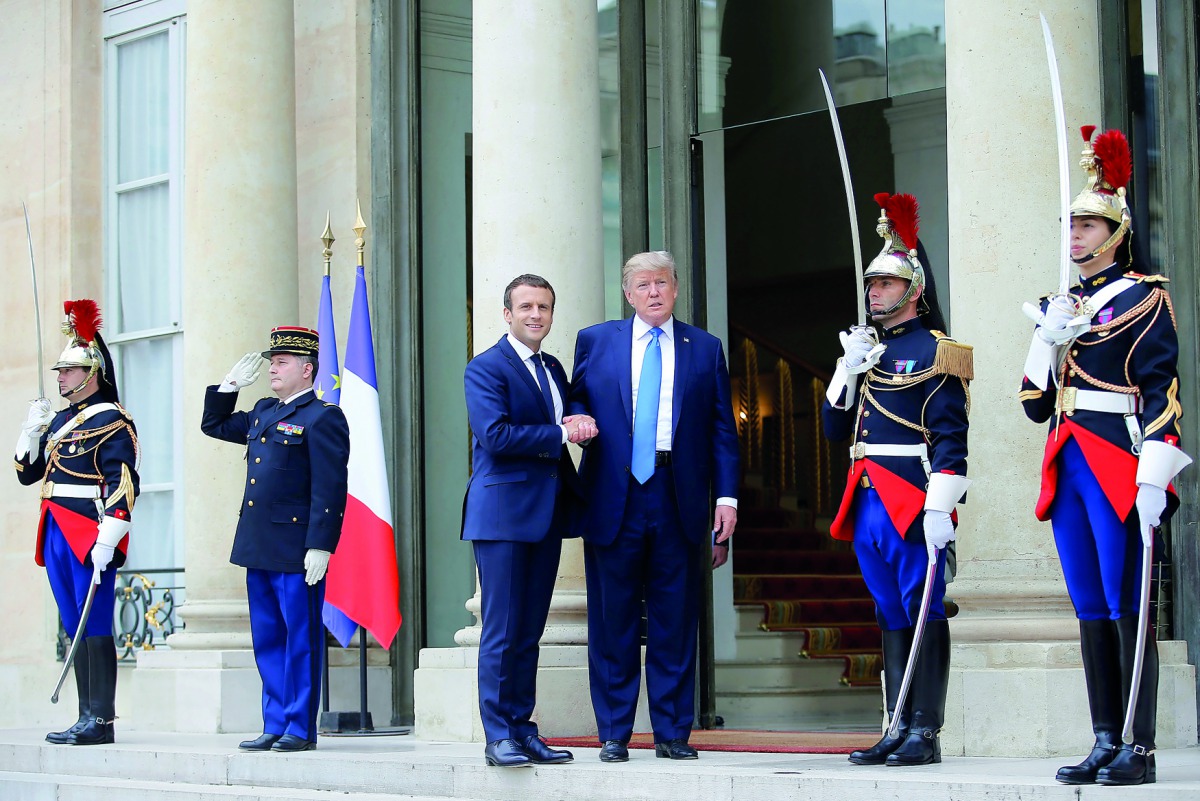 French President Emmanuel Macron greets US President Donald Trump at the Elysee Palace in Paris, yesterday.