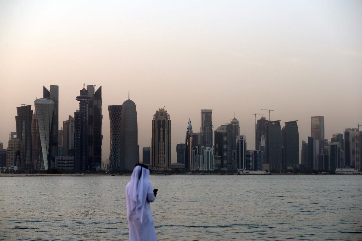 A man looks at his phone on the corniche of the Qatari capital Doha on July 2, 2017 (AFP)