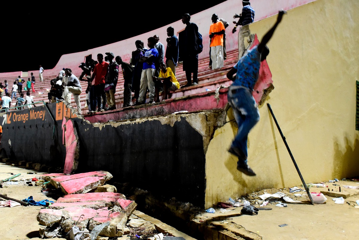 People look at the scene after a wall collapsed at Demba Diop stadium July 15, 2017 in Dakar after a football game between local teams Ouakam and Stade de Mbour. AFP / Seyllou