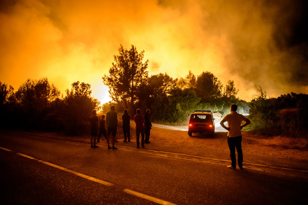 Local men look on during the extinguishing operation in Tivat, Montenegro on July 18, 2017. 150 fire department workers, soldiers and local people mobilized to extinguish the forest fires in Western Balkan countries; Montenegro, Croatia and Bosnia and Her