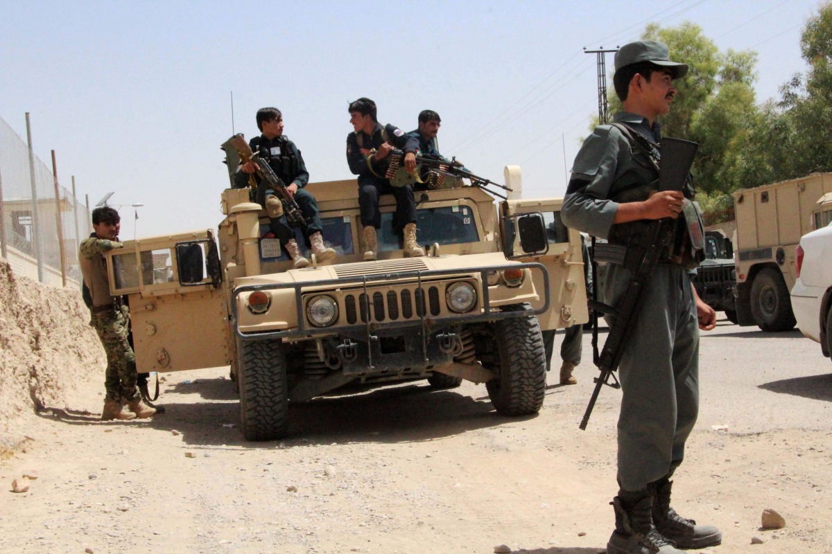 Afghan security personnel sit on atop an armoured vehicles amid an ongoing battle with Taliban militants in the Gereshk district of Helmand province on July 22, 2017. (AFP / NOOR MOHAMMAD)
