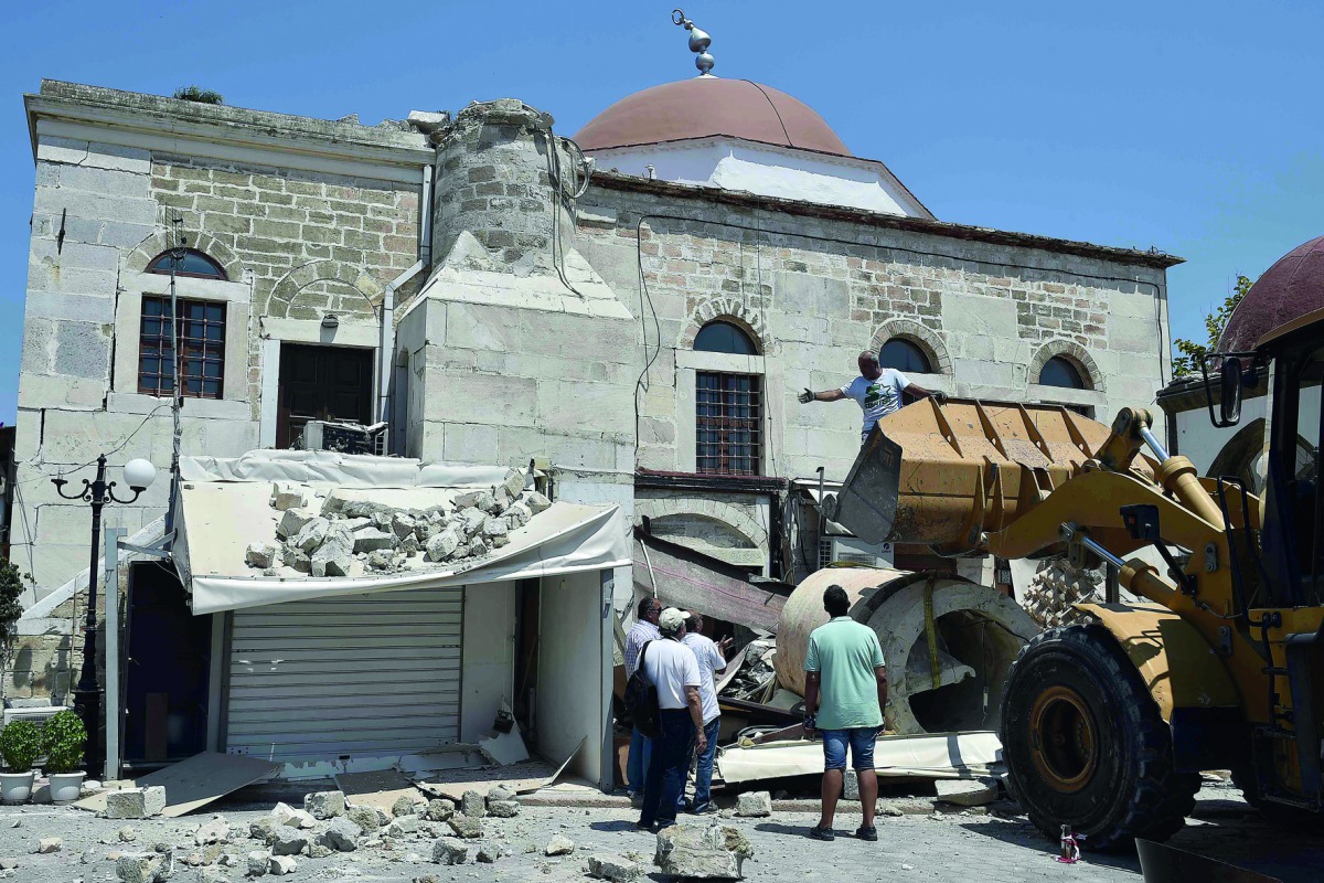 Workers remove rubble from a quake-damaged mosque in the central square of the Greek Island of Kos, yesterday.