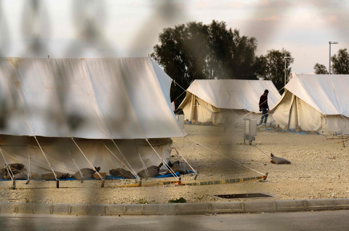 A Syrian refugee walking in between tents at a reception centre in Kokkinotrimithia on the outskirts of the Cypriot capital Nicosia. Cypriot authorities said a boat carrying over 140 migrants believed to be Syrians was escorted to shore by the coast guard
