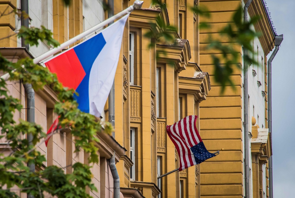 A Russian flag flies next to the US embassy building in Moscow on July 31, 2017. President Vladimir Putin on July 30, 2017 said the United States would have to cut 755 diplomatic staff in Russia and warned of a prolonged gridlock in its ties after the US 