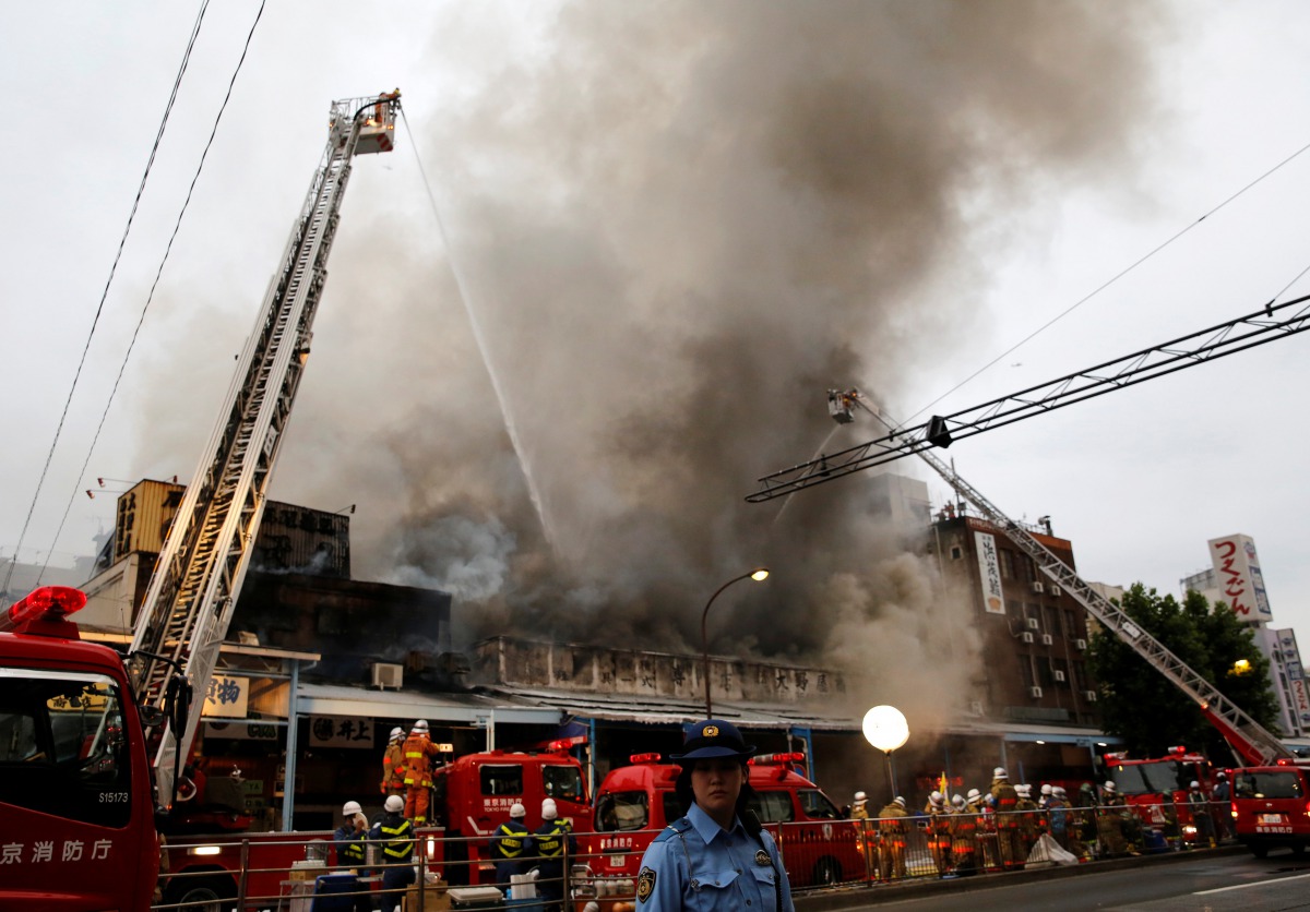 Firefighters operate at the fire site at Tokyo's Tsukiji fish market in Tokyo, Japan August 3, 2017. (REUTERS/Toru Hanai)