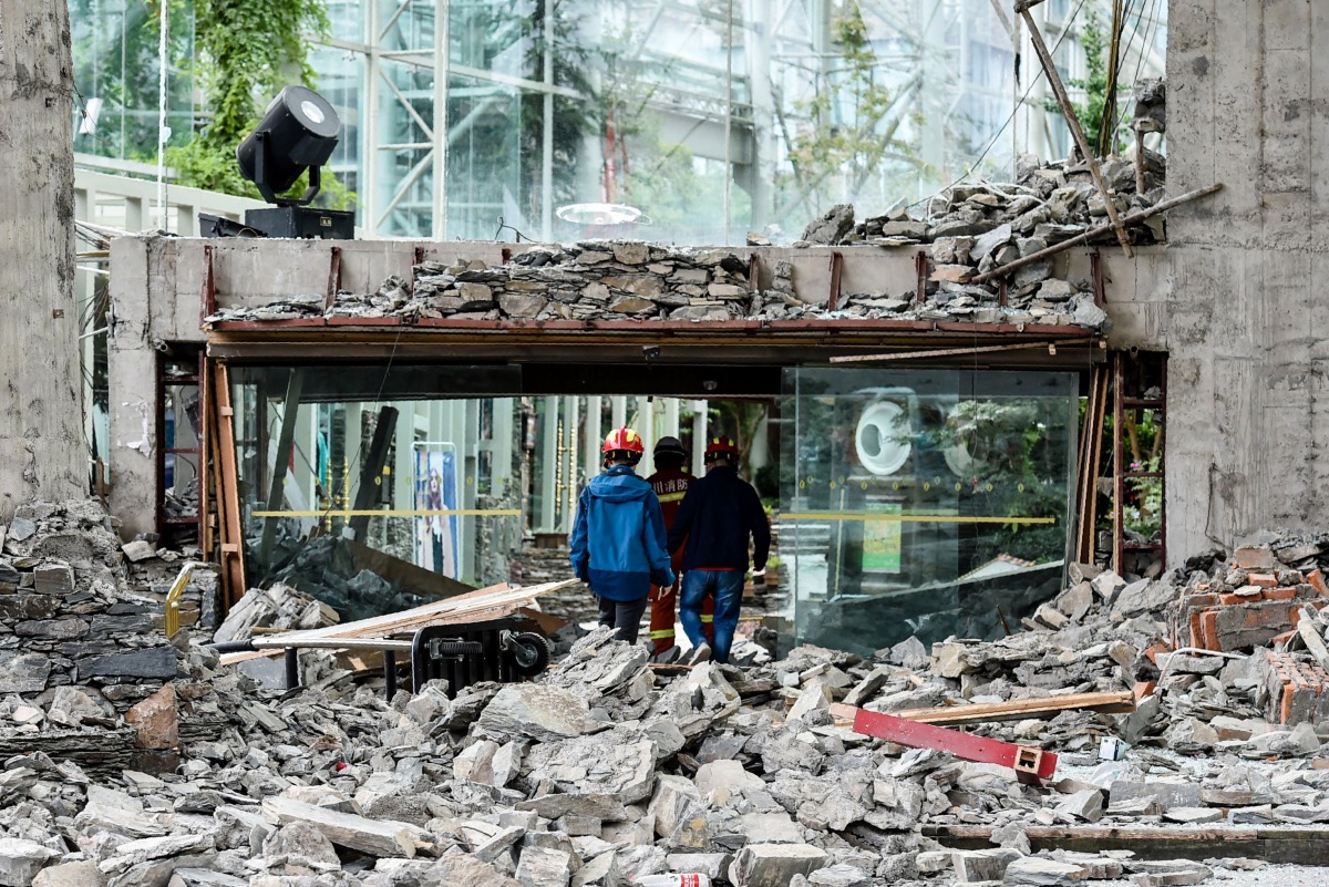 This photo taken on August 10, 2017 shows rescuers walking through the damaged InterContinental Resort Jiuzhai Paradise in Jiuzhaigou in China's southwestern Sichuan province, after an 6.5-magnitude earthquake struck the province late on August 8. AFP