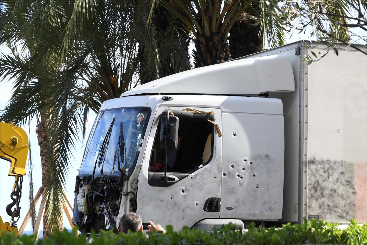 The truck riddled with bullets that was driven by a man through a crowd celebrating Bastille Day being towed away by breakdown lorry in the French Riviera city of Nice, July 15, 2016 (AFP Boris Horvat)