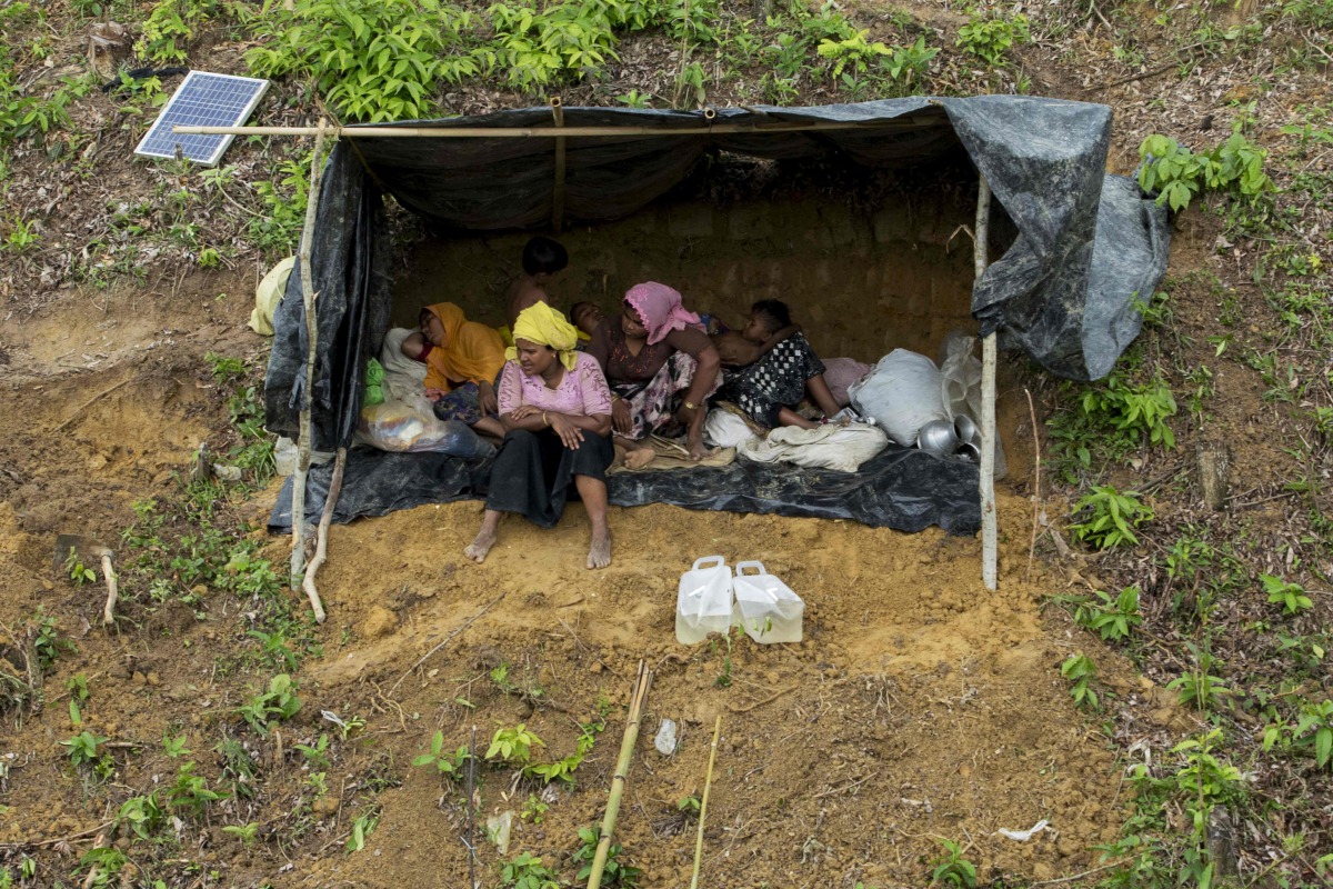 Displaced Rohingya women and children sit in a makeshift shelter in a mountain in Ukhiya, as members of the Rohingya Muslim minority fleeing unrest take shelter in a no-man's land between Bangladesh and Myanmar on September 4, 2017. AFP / K.M. Asad