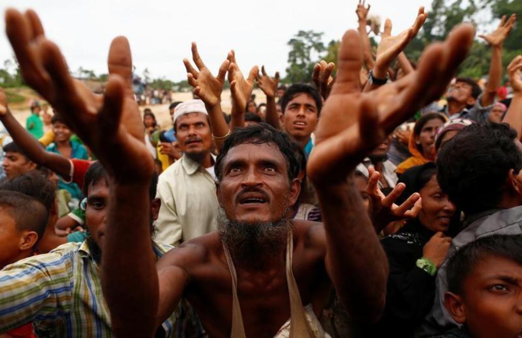 FILE PHOTO: Rohingya refugees stretch their hands to receive food distributed by local organizations in Kutupalong, Bangladesh, September 9, 2017. REUTERS/Danish Siddiqui.