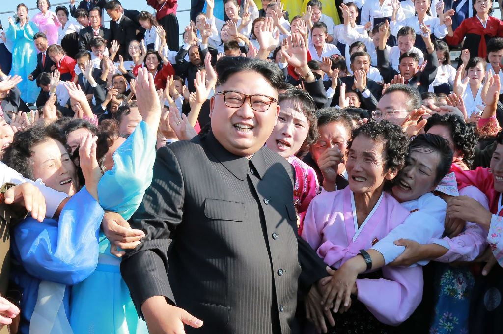 This undated picture released from North Korea's official Korean Central News Agency (KCNA) on September 12, 2017 shows North Korean leader Kim Jong-Un (C) attending a photo session with teachers who volunteered to work at branch schools on islands and sc