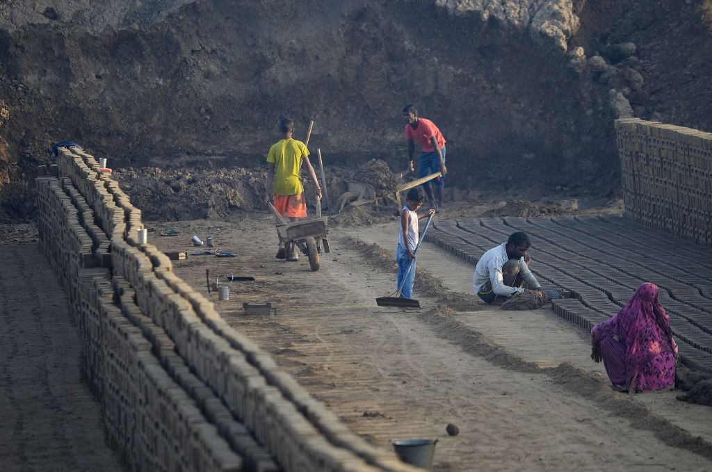 This photograph taken on September 18, 2017 shows Indian labourers working in a brick kiln on the outskirts of Jalandhar on September 18, 2017. AFP / SHAMMI MEHRA 
